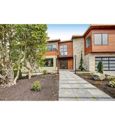 a large house with lots of windows and trees in front of the entrance to it