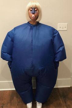 a woman with white hair wearing a blue sumo suit