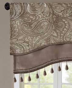 an elegant window valance with tassels hanging from it's rod ends