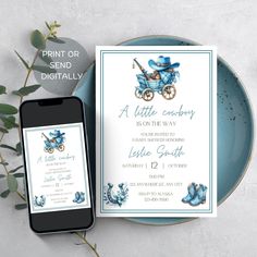 a blue baby carriage is on the table next to an open cell phone and card