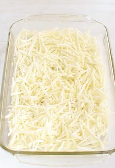 shredded cheese in a glass casserole dish ready to be baked or put into the oven