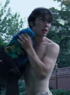 a shirtless young man holding a stuffed animal