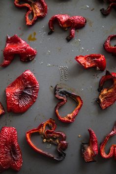 red peppers are on a baking sheet and have been burnt to make them look like they're eating something