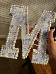 the letter n is made out of pearls and beaded letters are decorated with flowers