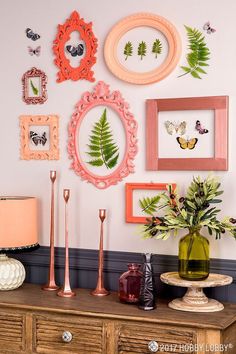 there are many frames on the wall with flowers and plants in vases next to them