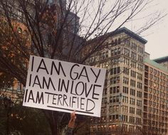 a person holding up a sign that says i am gay and i am not interested