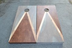 two pieces of wood sitting next to each other on the ground with holes in them