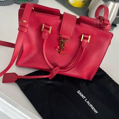 Gently Used Ysl Red Monogram Cabas Leather Tote. Some Wearing On The Inside And On The Bottom Corners As Shown In The Picture’s. Dust Bag Included. Measurements: Width: 10” Height: 7” Depth: 4” High-end Red Shopping Bag, High-end Red Crossbody Bag, Luxury Red Satchel For Daily Use, High-end Red Bag For Everyday Use, Designer Red Satchel For Shopping, Chic Red Bags For Everyday Luxury, Red Bags With Gold-tone Hardware For Everyday Luxury, High-end Red Shoulder Bag With Branded Hardware, Designer Red Bag With Branded Hardware