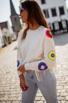 This cozy-chic ecru sweater boasts of a crewneck design, showcasing colorful embroidered flowers and delicate fringe detailing on the long sleeves. Our models are also wearing the Blue Maddie Jeans and the Light Blue Hunter Jeans One size (fits from US sizes 2-10) Length 22.0 in - Width 19.3 in 42% Acrylic - 30% Polyamide - 28% Polyester Washing: Handwash only Bohemian Fringe Sweater For Spring, Spring Bohemian Sweater With Tassels, Spring Long Sleeve Sweater With Tassels, Bohemian Spring Sweater With Fringe, Winter Multicolor Sweater With Ribbed Cuffs, Casual Winter Sweater With Floral Embroidery, Playful Colorful Winter Sweater, Spring Long Sleeve Sweater With Fringe, Multicolor Embroidered Long Sleeve Spring Sweater