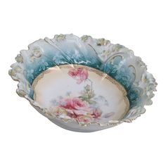 a blue and white bowl with pink flowers on the rim, sitting in front of a white background