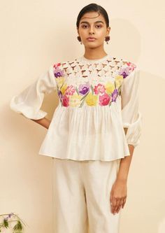 Editor's Note Featuring an ivory chanderi floral applique and cutwork top Note: Pant worn by model is for styling purposes and can be purchased separately. Color: Ivory Fabric: Chanderi Component: Top Occasion: Resort and daywear Care: Dry Clean Only About the Designer Chandrima celebrates diversity in cultures and craft forms creating ready-to-wear women wear for the urban woman of today. The brand embodies the idea of Indian handloom and craft merged with an international style. Label Chandrim Luxury Unstitched Blouse In Chinon For Traditional Wear, Luxury Cotton Tops With Resham Embroidery, Luxury Chanderi Blouse Piece For Party Wear, Luxury Chanderi Blouse For Party Wear, Luxury Cream Embroidered Tops, Luxury Chic Tops With Cutwork Hem, Luxury Unstitched Tops, Luxury Chanderi Embroidered Top With Dori Work, Luxury Chanderi Top With Dori Embroidery