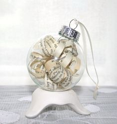 a glass ornament filled with books and ribbons