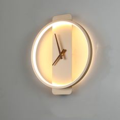 a clock that is on the wall with light coming from it's face and hands