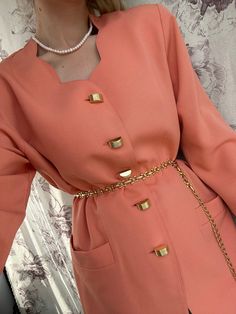 This vintage orange coral long blazer is a classy and sophisticated jacket that demands attention. Its orange coral color adds a pop of boldness and energy to any outfit. The unique golden buttons add a touch of elegance and elevate the overall aesthetic of the blazer. With its longer length, it exudes a sense of refinement and versatility. This vintage piece is perfect for those who want to make a stylish statement and showcase their individuality with a touch of retro flair. - Good vintage con Elegant Orange Spring Outerwear, Elegant Fall Orange Blazer, Elegant Orange Blazer For Office, Elegant Orange Fall Blazer, Elegant Orange Office Outerwear, Elegant Orange Office Blazer, Luxury Orange Elegant Outerwear, Orange Long Sleeve Formal Blazer, Elegant Long Sleeve Orange Blazer