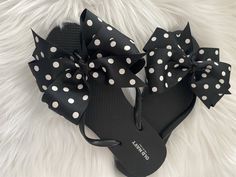 A pair of Old Navy flip flops decorated with a black grosgrain ribbon adorned with white polka dots. Ribbons are hand sewn to the shoe by me!! Super cute and fun!! Great for poolside or the beach, adorable for anywhere!! Three loops of one and a half inch ribbon made into a pinwheel bow that measures approximately 5 inches wide. Ends are heat sealed for no fraying. I'll be coming out with more colors soon so come back and visit!! Thank you for stopping by!! Custom requests are always welcome. Pl Casual Summer Flip Flops With Bow, Adjustable Black Summer Flip Flops, Cute Bow Sandals For The Beach, Adjustable Bow Sandals For Beach, Summer Beach Flip Flops With Bow, Black Bow Sandals For Summer, Summer Bow Flip Flops With Open Toe, Adjustable Bow Sandals For Vacation, Adjustable Cute Flip Flops For Vacation