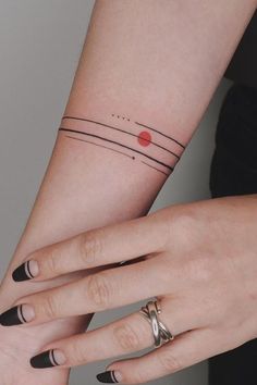 two women's hands with matching tattoos on their wrists and wrist, both holding each other