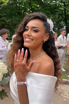 a woman in a white dress holding her hand up to show the number one on her wedding day