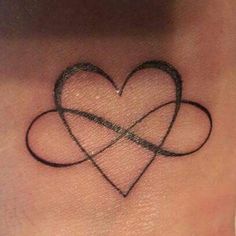 a small heart tattoo on the side of a woman's neck with two intertwined hearts