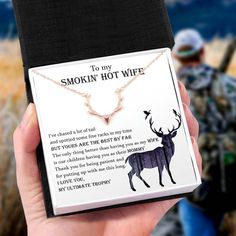 a person holding up a card with a deer on it's back and the words to my smokin'hot wife