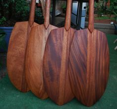 three wooden paddles sitting on top of each other