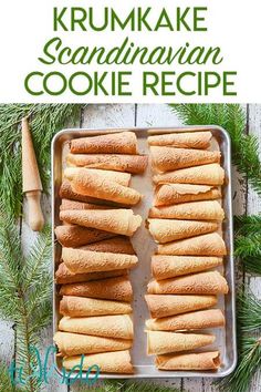 a pan filled with cookies on top of a wooden table next to pine cones and cinnamon sticks