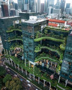 an aerial view of a city with tall buildings and greenery on the top floors