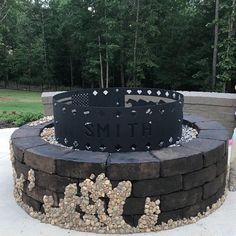 a fire pit with rocks around it and a sign on the side that says smith