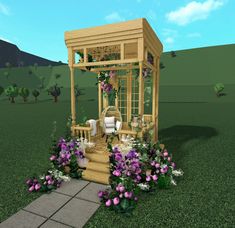 a small wooden gazebo sitting on top of a lush green field next to flowers