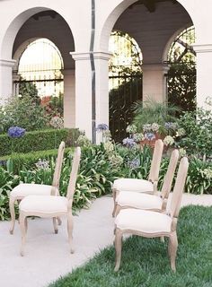 four chairs sitting in the middle of a garden