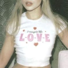 a woman sitting in a chair wearing a t - shirt with the word love on it