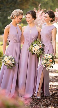 three bridesmaids in purple dresses standing next to each other