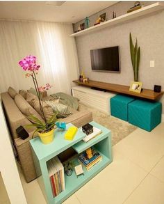 a living room filled with furniture and a flat screen tv on top of a wooden table