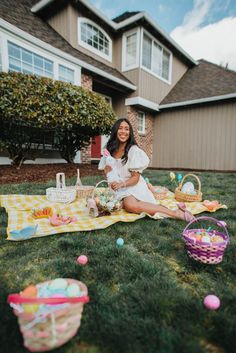 a woman sitting in the grass with some baskets and eggs