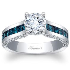 a white gold engagement ring with blue and white diamonds on the band, set in 18k white gold