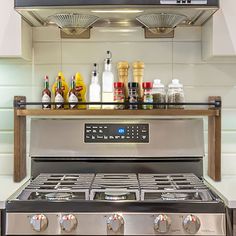 an oven with two burners and bottles on the shelf above it in a kitchen