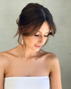 a woman wearing a white strapless dress holding a cell phone