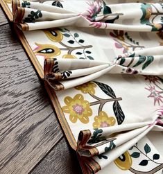 a close up of a flowered cloth on a wooden table with wood flooring