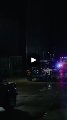 two police cars parked in a parking lot at night