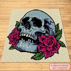 a cross stitch skull with roses on it's face is shown in this image