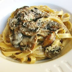 pasta with mushrooms and parmesan cheese in a white bowl