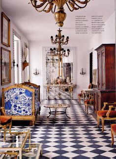 an ornately decorated living room with blue and white checkered flooring, chandelier