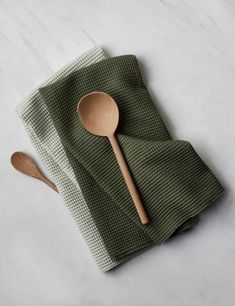 a wooden spoon sitting on top of a green napkin