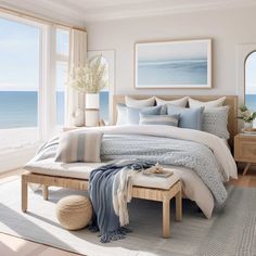 a bedroom with a large window and a bed in front of an ocean side view