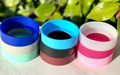 three different colored bracelets sitting next to each other on top of a white table