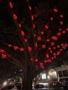 a tree that has been decorated with red lights in the shape of hearts on it