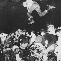 a man flying through the air while riding a skateboard in front of a crowd