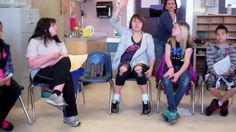 a group of children sitting in chairs with their teacher