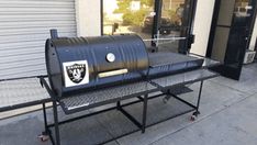 a bbq grill sitting on top of a metal stand outside of a store front