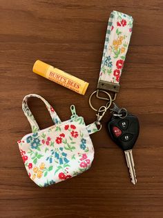 the keychain has two keys in it and is next to a small purse