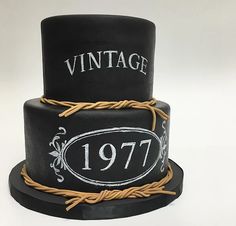 a black and white cake with an old fashioned label on it's top tier